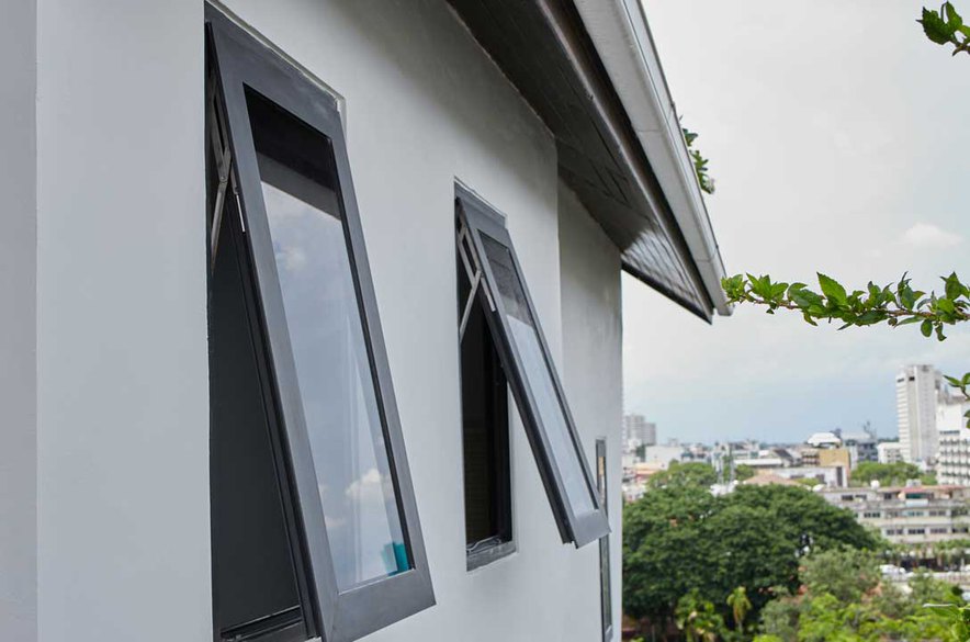 Outside view from a client's house showing a white wall with casement window vs sliding window